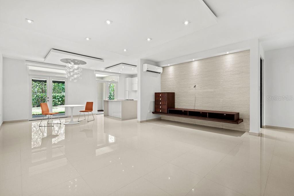 A bright, open-concept living and dining area features white tile floors and a textured wall — 693 PR UNIT 413, VEGA ALTA, PR