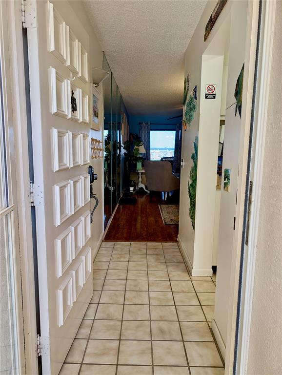A tiled entryway leads into a living area with hardwood floors and a view of water — 6218 PALMA DEL MAR BOULEVARD S UNIT 114, ST PETERSBURG, FL