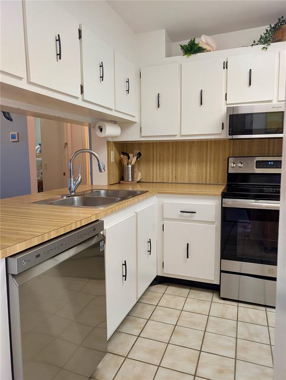 A kitchen with white cabinets, stainless steel appliances, and wood-look laminate countertops — 6218 PALMA DEL MAR BOULEVARD S UNIT 114, ST PETERSBURG, FL