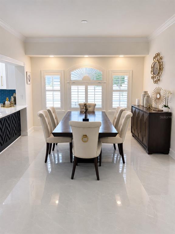 A dining room features a dark wood table, upholstered chairs, and a dark sideboard — 452 BATH CLUB BOULEVARD N, NORTH REDINGTON BEACH, FL