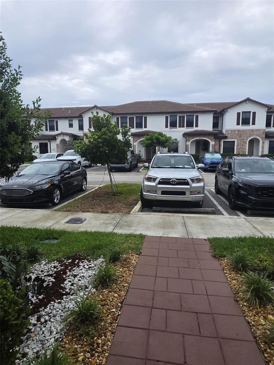 A parking lot with several cars sits in front of a two-story residential building — 10963 W 32nd Ln, Hialeah FL 33018, HIALEAH, FL