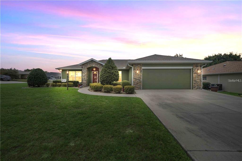 A single-story house with a green exterior, stone accents, and a two-car garage — 6014 SW 86TH LANE, OCALA, FL