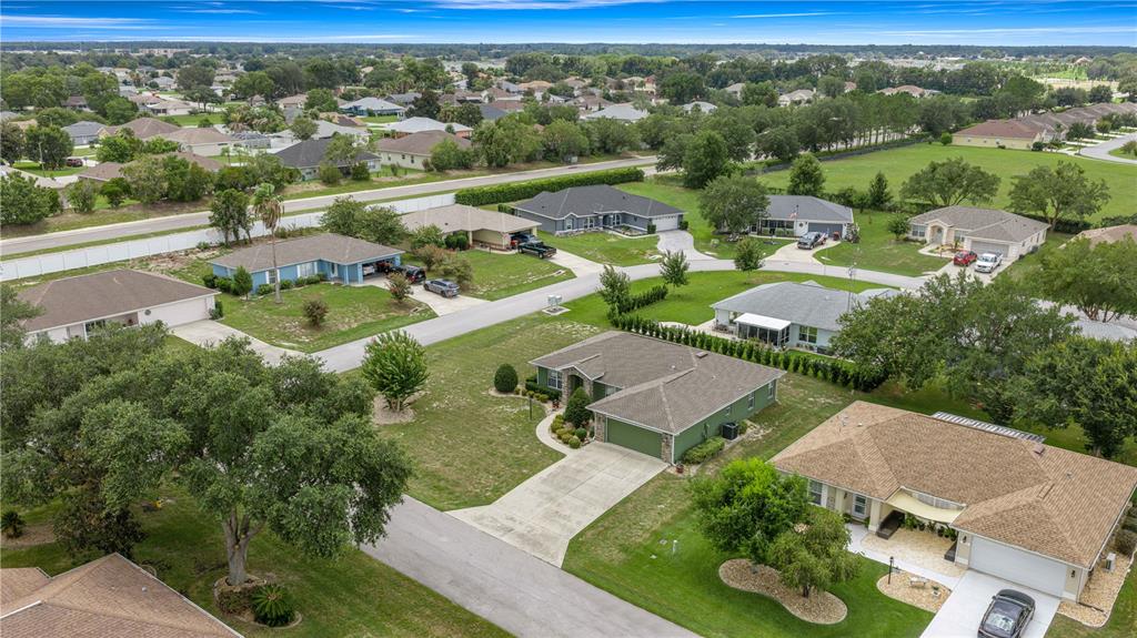 An aerial view shows a suburban neighborhood with several single-family homes and green lawns — 6014 SW 86TH LANE, OCALA, FL
