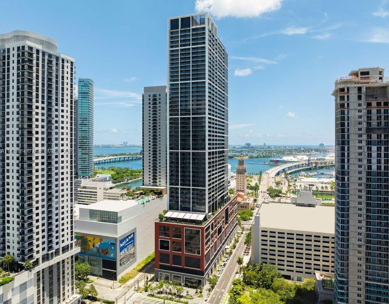 An aerial view shows a tall, modern skyscraper in downtown Miami near the waterfront — 159 NE 6 # 3912, Miami FL 33132, MIAMI, FL