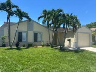 A single-story house with a beige exterior, a garage, and palm trees in the front yard — 18970 Cloud Lake Circle, Boca Raton FL 33496, BOCA RATON, FL