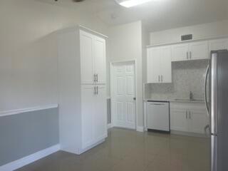 A kitchen with white cabinets, a dishwasher, a sink, and light-colored tile flooring — 18970 Cloud Lake Circle, Boca Raton FL 33496, BOCA RATON, FL