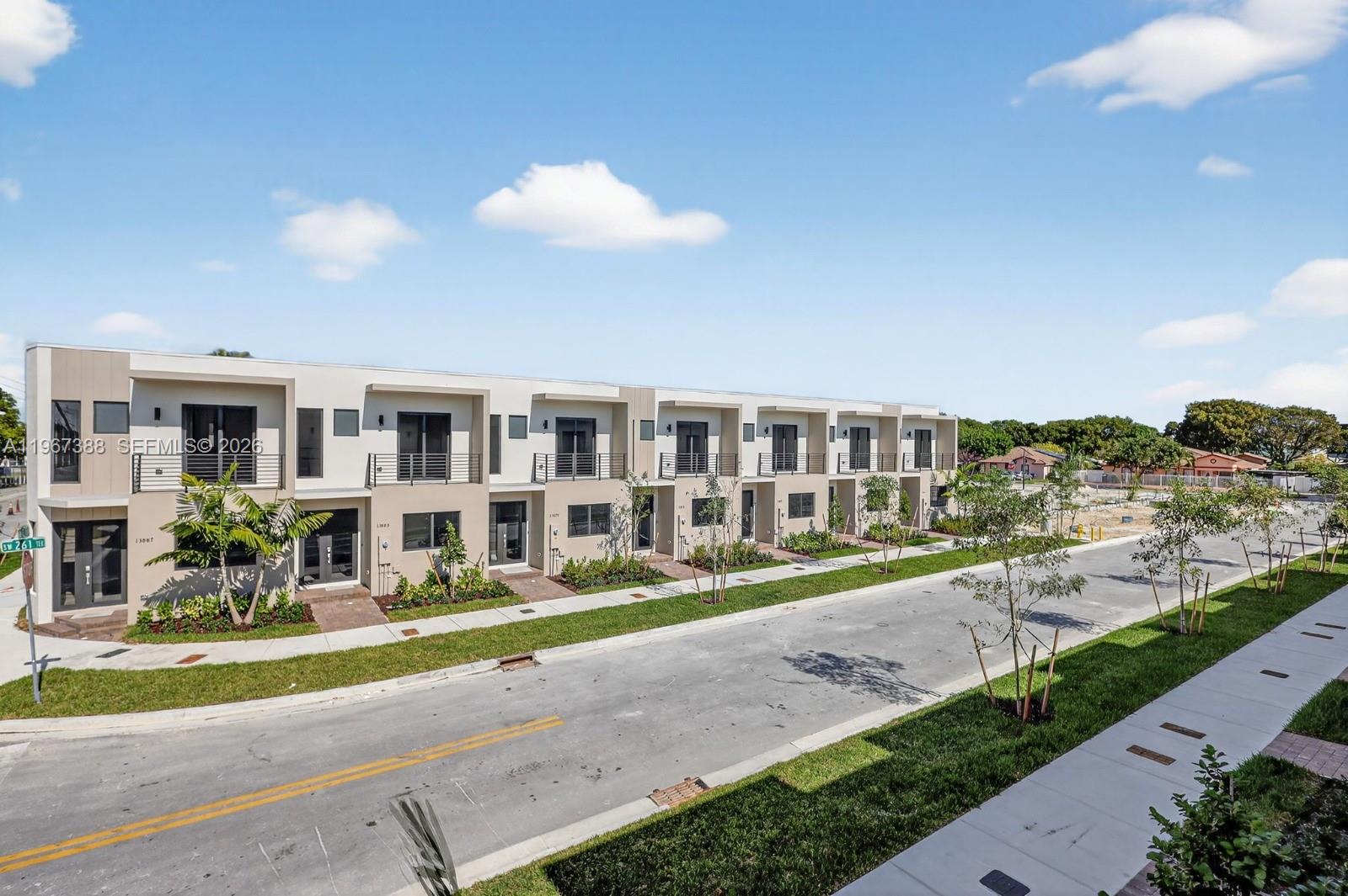 A row of modern two-story townhouses features balconies, flat roofs, and landscaped front yards — 13888 SW 261st Ter # 0, Miami FL 33032, MIAMI, FL
