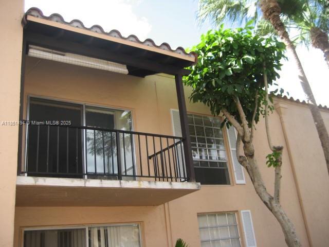 A two-story building exterior features a second-floor balcony with a black metal railing — 10810 N Kendall Dr # 18, Miami FL 33176, MIAMI, FL