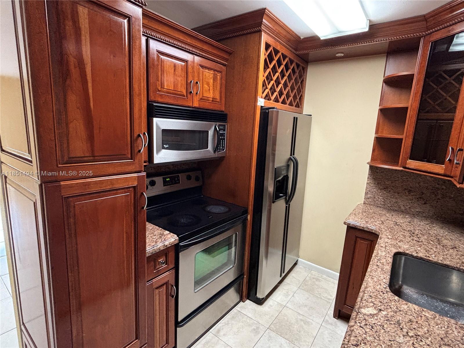 A kitchen features wood cabinetry, stainless steel appliances, and granite countertops — 10810 N Kendall Dr # 18, Miami FL 33176, MIAMI, FL