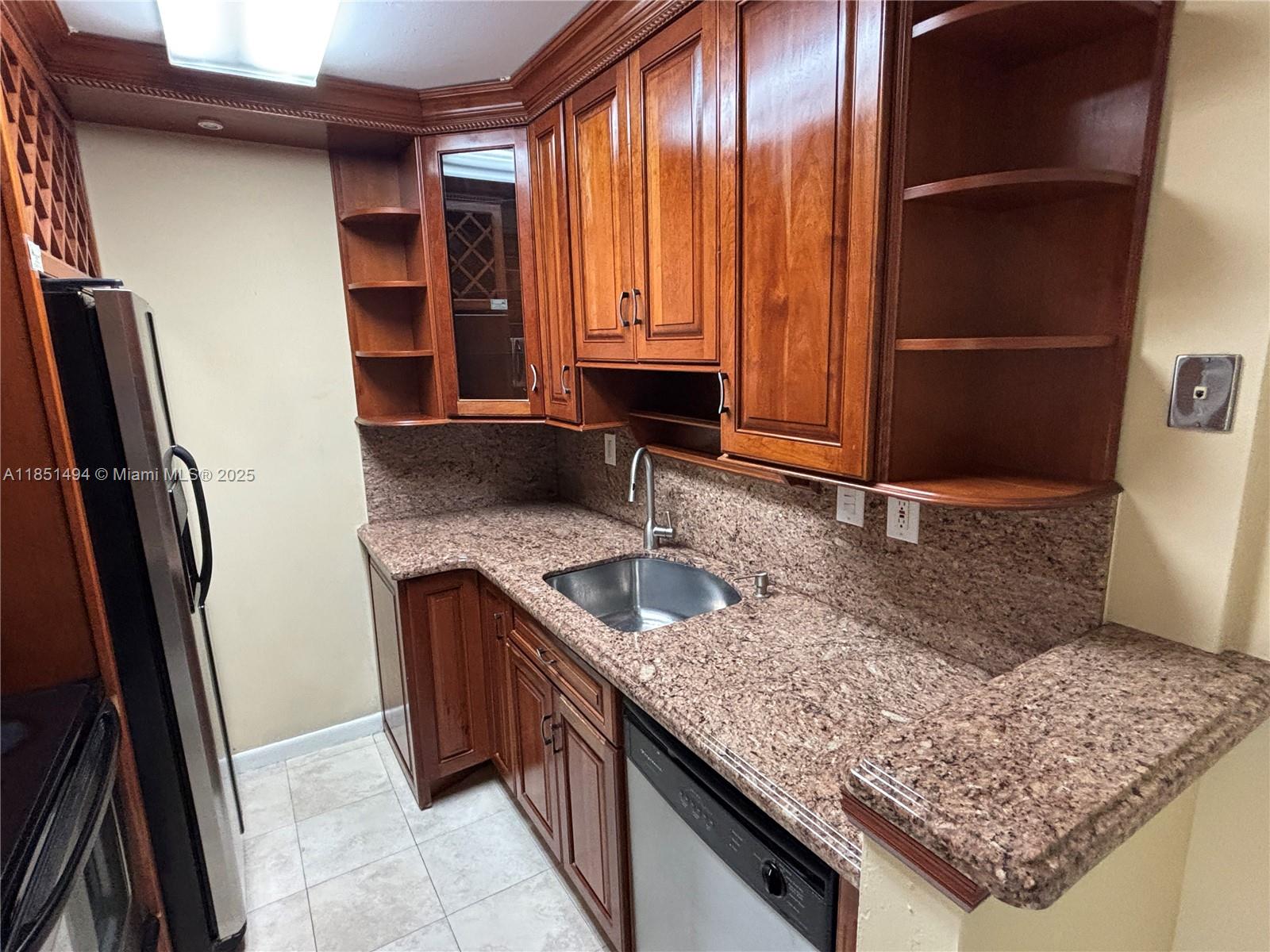 A kitchen features wood cabinets, granite countertops, a stainless steel sink, and a dishwasher — 10810 N Kendall Dr # 18, Miami FL 33176, MIAMI, FL