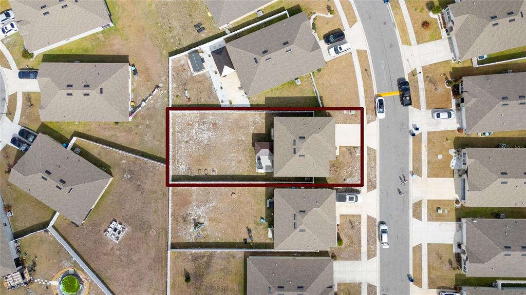 This aerial view shows a residential house with a fenced backyard in a suburban neighborhood — 740 SQUIRES GROVE DRIVE, WINTER HAVEN, FL