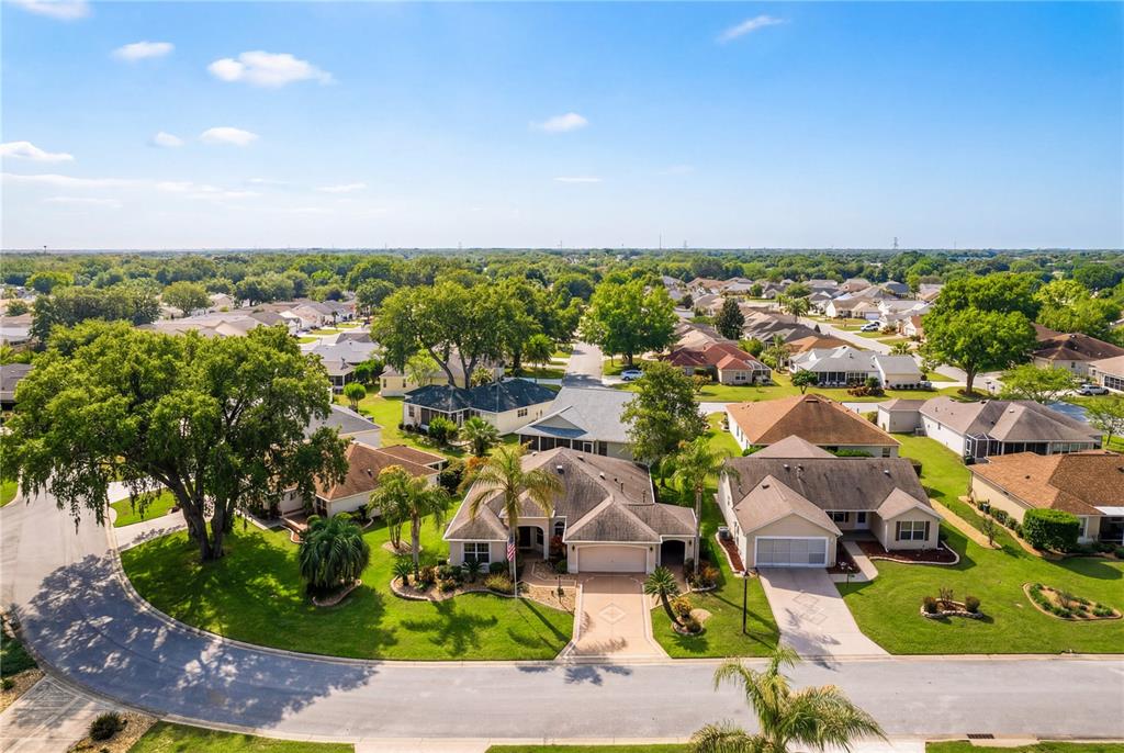 An aerial view shows suburban houses with shingled roofs and green lawns on a street — 16905 SE 93RD CUTHBERT CIRCLE, THE VILLAGES, FL
