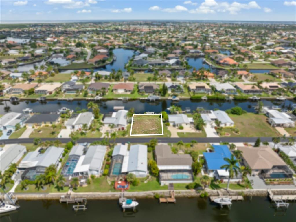 An aerial view shows a vacant rectangular lot outlined in white within a residential neighborhood — 5439 RIVER BAY DRIVE, PUNTA GORDA, FL