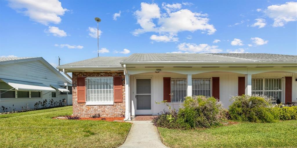 A single-story house with a brick facade, white siding, and a covered front porch — 1213 8TH STREET NW, WINTER HAVEN, FL