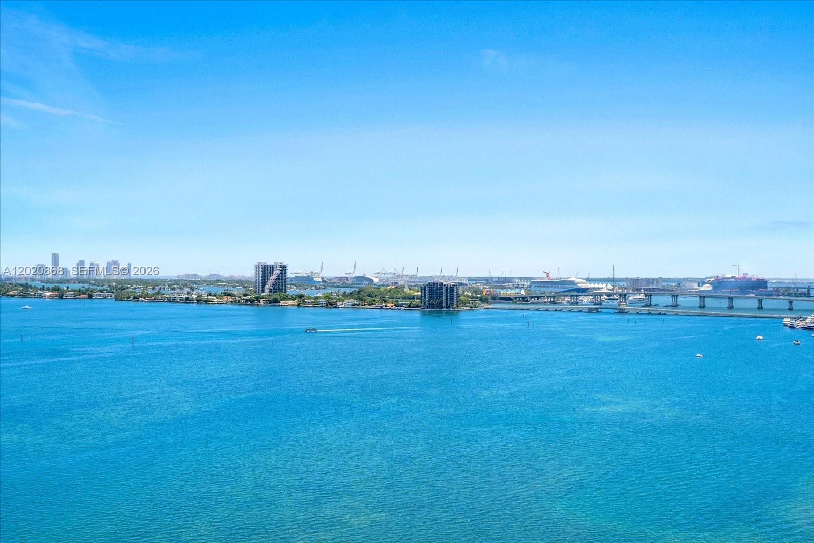 A high-angle view of a blue bay with a bridge and distant city skyline — 700 NE 24th St # 1602, Miami FL 33137, MIAMI, FL