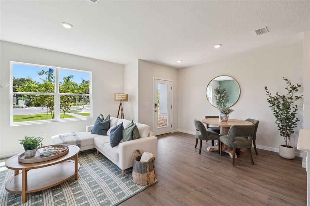 A living and dining area features wood-look flooring, a white sectional sofa, and a table — 2253 RITA LANE, KISSIMMEE, FL