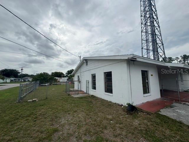 The exterior of a white, single-story building with a metal communication tower nearby — 5018 GRAND BOULEVARD, NEW PORT RICHEY, FL
