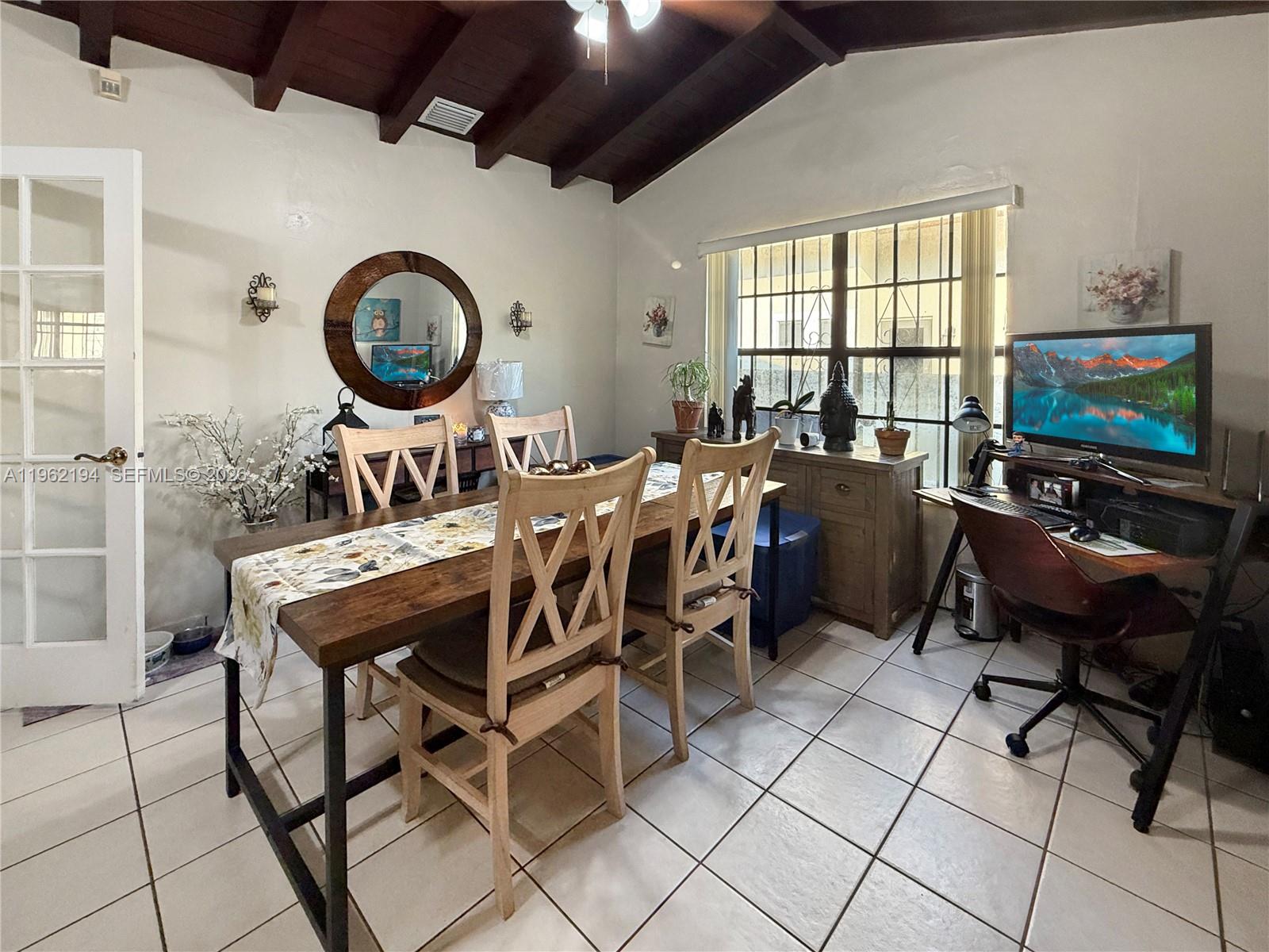 A dining room features a wooden table, chairs, tile flooring, and a computer desk area — 8891 SW 28th St, Miami FL 33165, MIAMI, FL