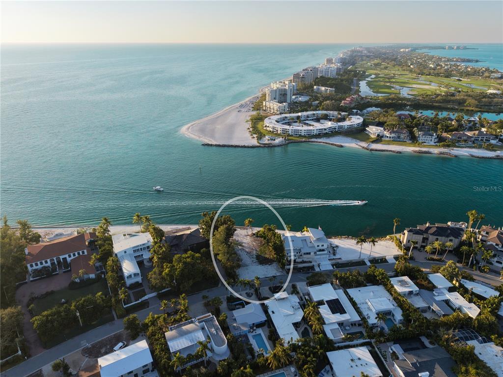 An aerial view shows a vacant waterfront lot situated between two large residential homes — 1199 WESTWAY DRIVE, SARASOTA, FL