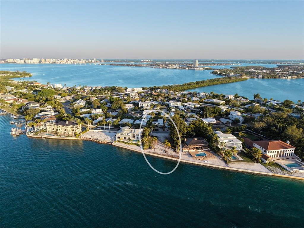 An aerial view shows a vacant waterfront lot situated between two large residential properties — 1199 WESTWAY DRIVE, SARASOTA, FL