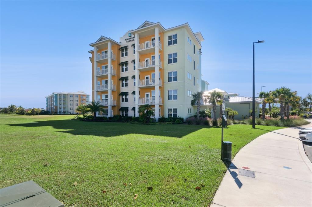 An exterior view of a multi-story Embassy Suites hotel building with balconies and surrounding landscaping — 3151 SUNSET WALK DRIVE UNIT 1202, KISSIMMEE, FL