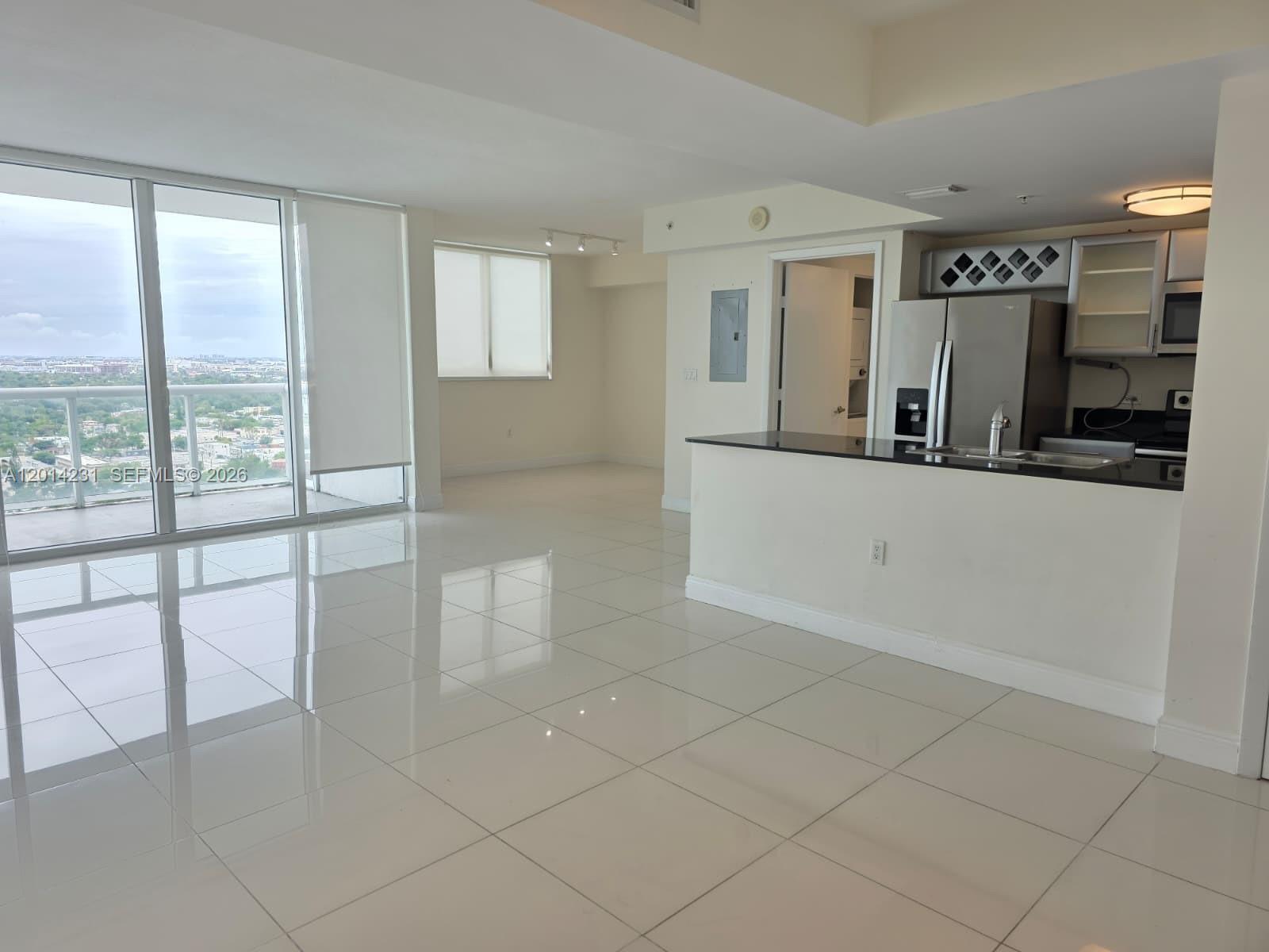 An open-concept living area features white tile floors, a kitchen island, and floor-to-ceiling windows — 1861 NW S River Dr # 2603, Miami FL 33125, MIAMI, FL