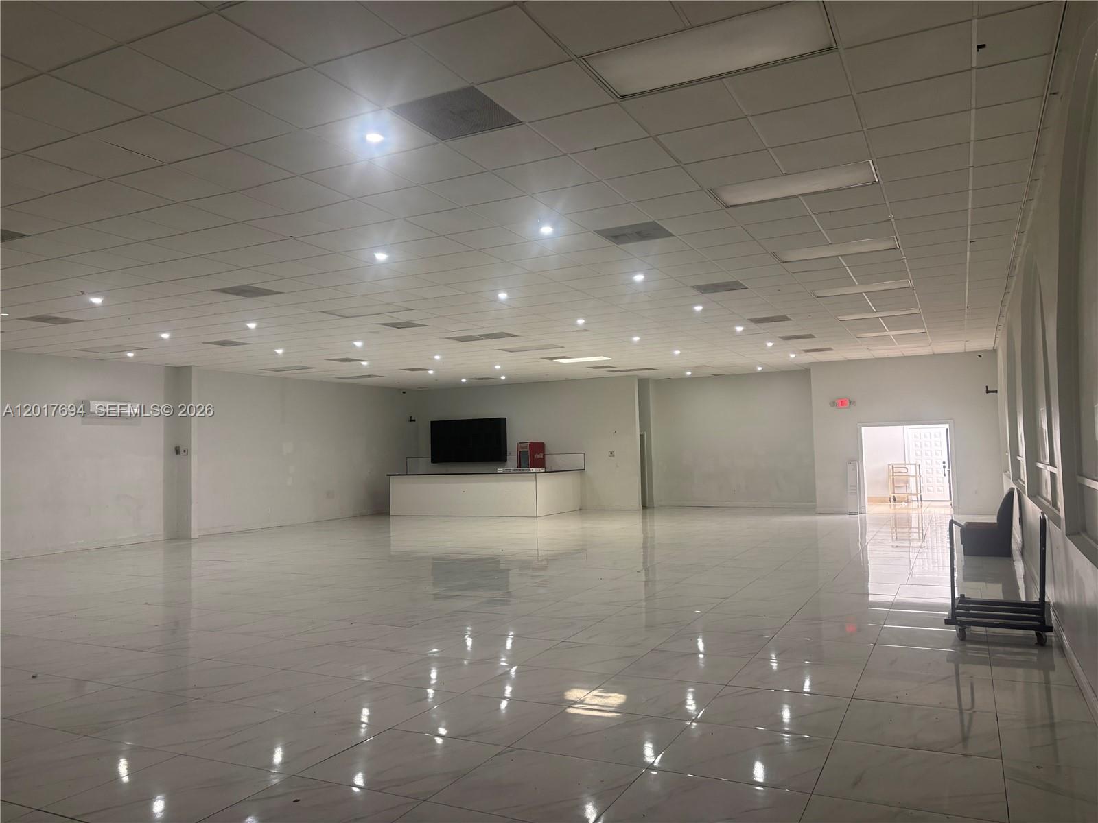 A large, open commercial space features white tiled floors, a drop ceiling, and a service counter — 4658 Palm Ave # B, Hialeah FL 33012, HIALEAH, FL
