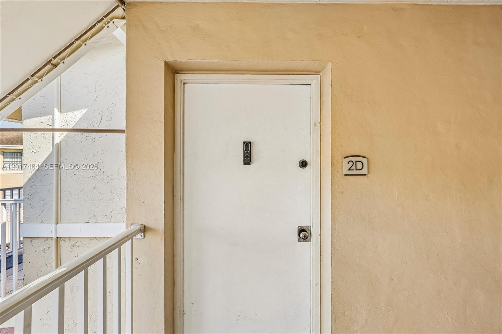 A white apartment door labeled 2D is set into a tan stucco exterior wall — 4520 NW 79th Ave # 2D, Doral FL 33166, DORAL, FL