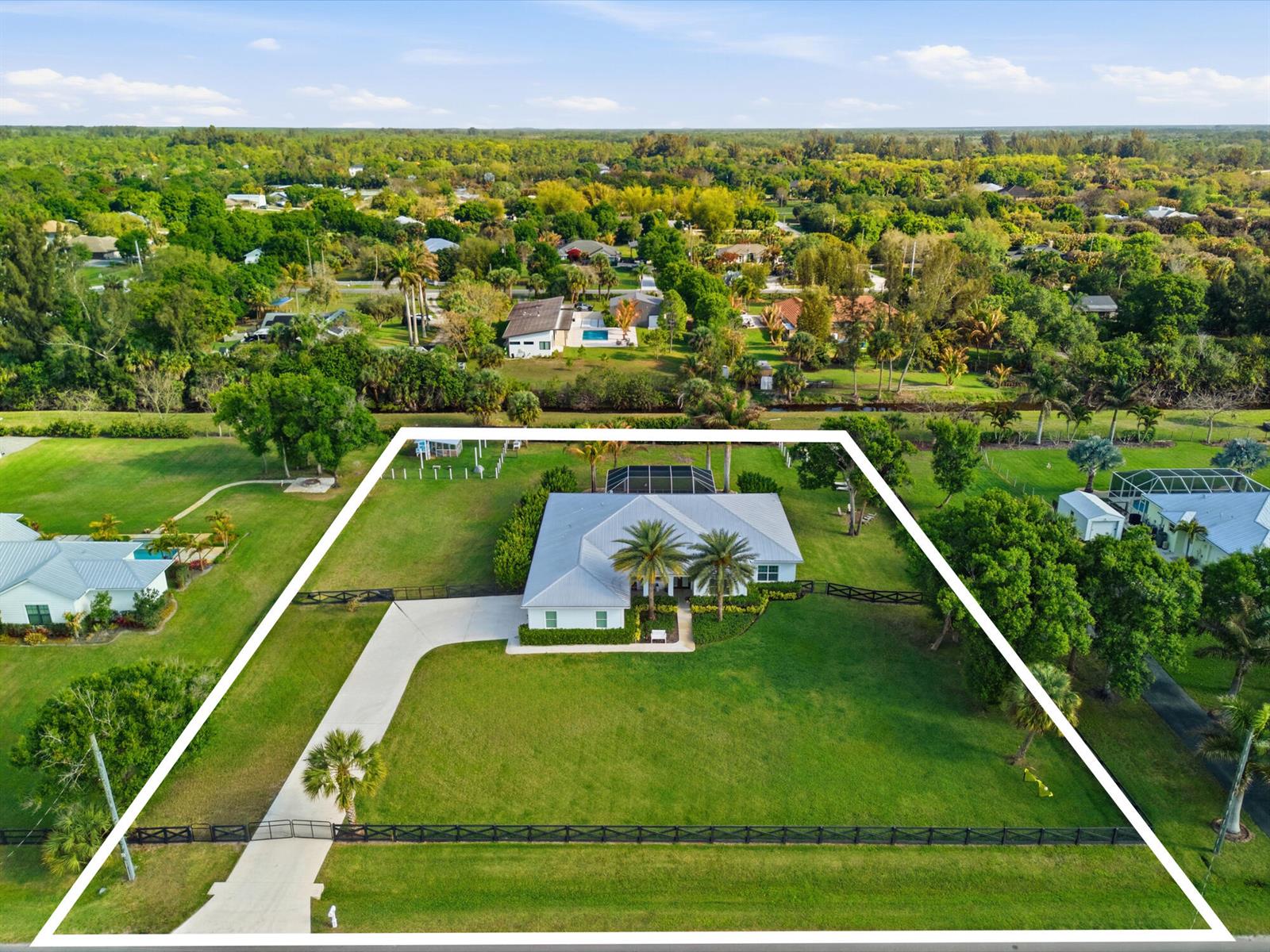 An aerial view shows a white house with a metal roof on a large lot — 9301 154th Road N, Jupiter FL 33478, JUPITER, FL