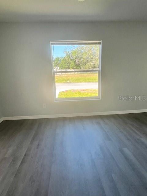 An empty room with light gray walls and wood-look flooring features a single window — 4076 OAK LOOP UNIT 4076, MULBERRY, FL