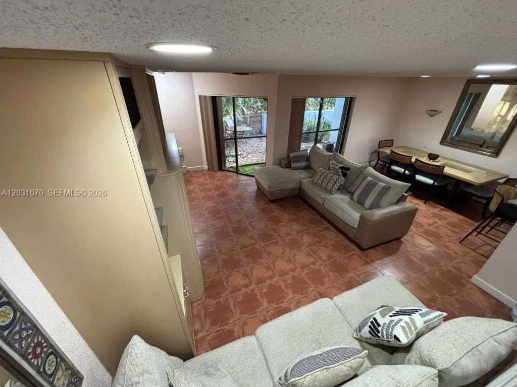 A living room with tile flooring, a sectional sofa, and a dining area — CORAL SPRINGS, FL