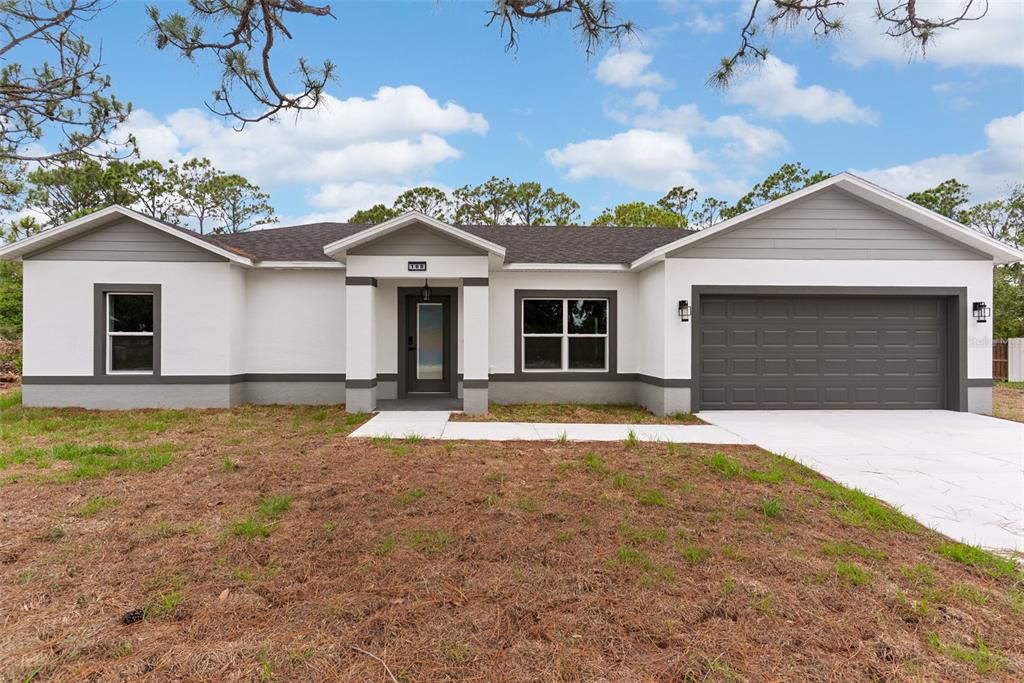 A single-story house with white stucco walls, gray trim, and a two-car garage — 108 OXBOW DRIVE, SEBRING, FL
