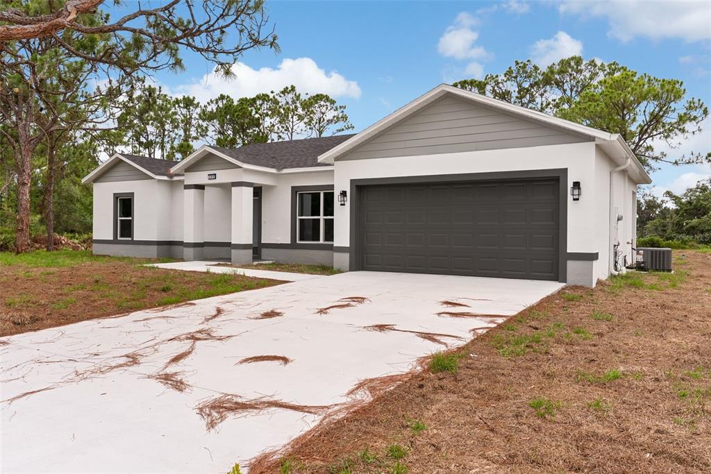 A single-story house with a white stucco exterior, gray trim, and a two-car garage — 108 OXBOW DRIVE, SEBRING, FL