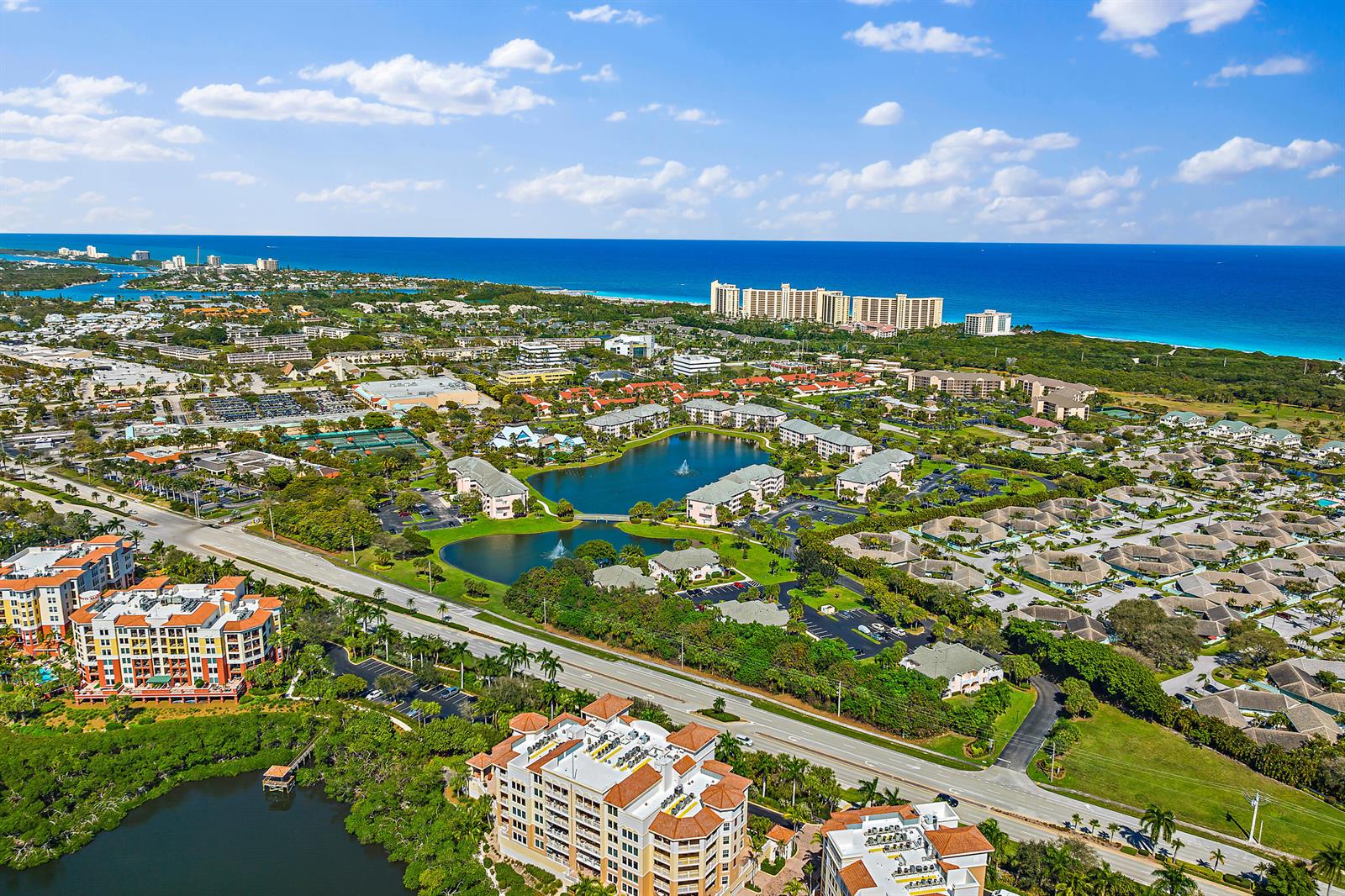 An aerial view shows a coastal community with apartment buildings, lakes, and nearby ocean beaches — 353 S Us Highway 1 # A105, Jupiter FL 33477, JUPITER, FL