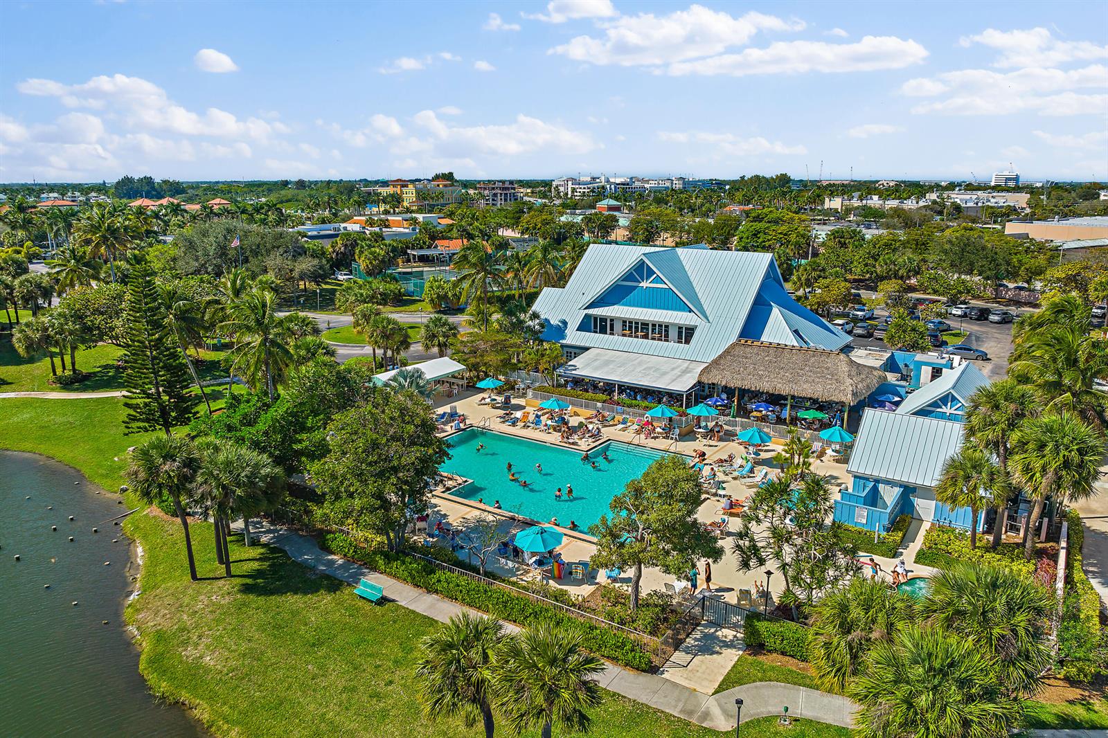 An aerial view shows a swimming pool and clubhouse surrounded by palm trees and landscaping — 353 S Us Highway 1 # A105, Jupiter FL 33477, JUPITER, FL