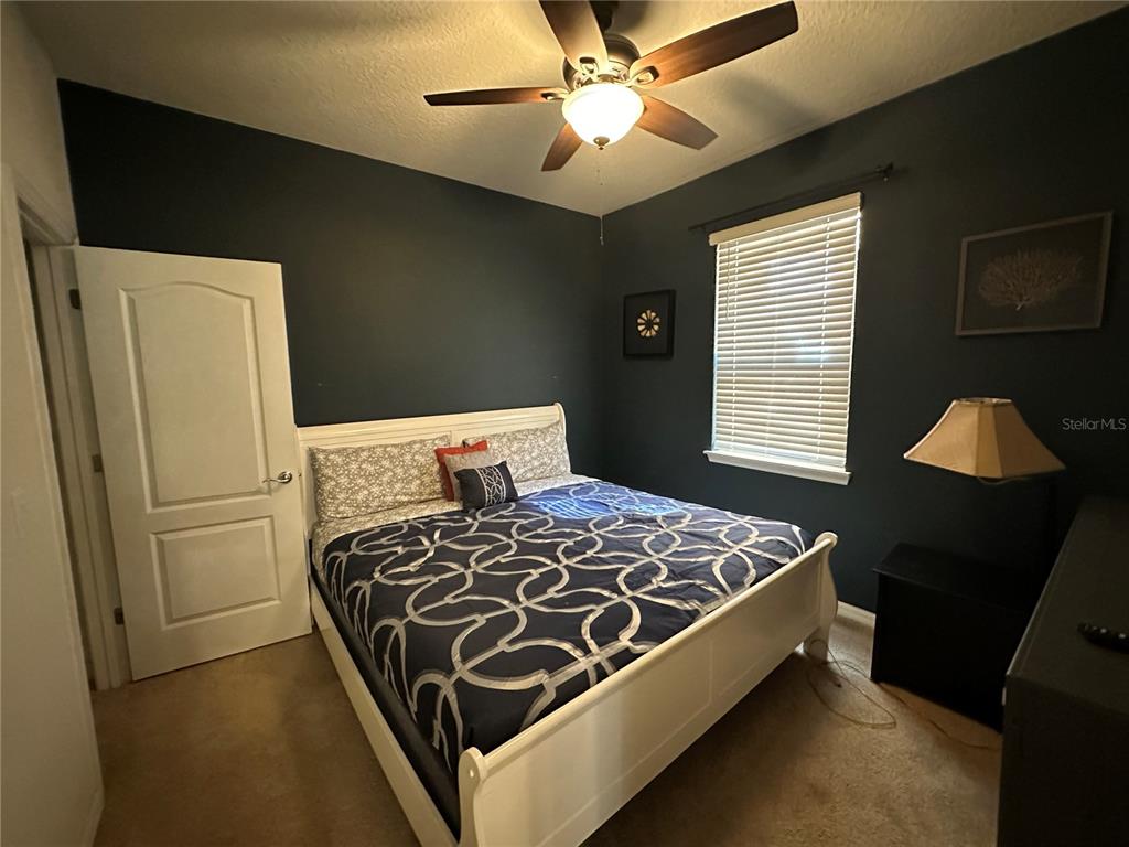 A kitchen features dark wood cabinets, granite countertops, a large island, and tile flooring — 1869 NICE COURT, KISSIMMEE, FL