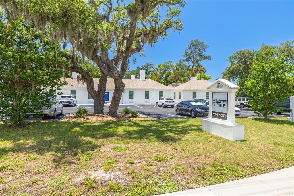 A white commercial building with a parking lot and a Baxter Title sign out front — 12800 INDIAN ROCKS ROAD, LARGO, FL
