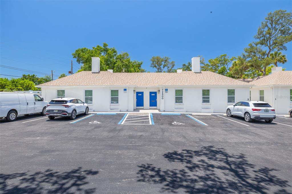 A white single-story building with blue doors and a parking lot with handicap spaces — 12800 INDIAN ROCKS ROAD, LARGO, FL