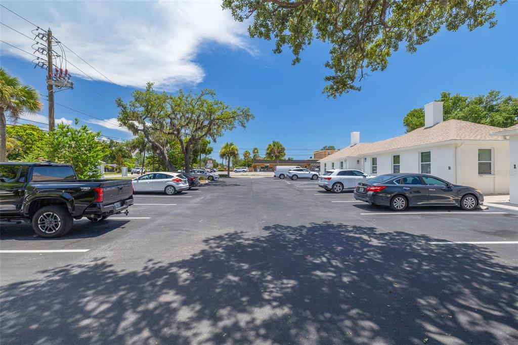 A parking lot with several parked cars sits in front of a white building — 12800 INDIAN ROCKS ROAD, LARGO, FL
