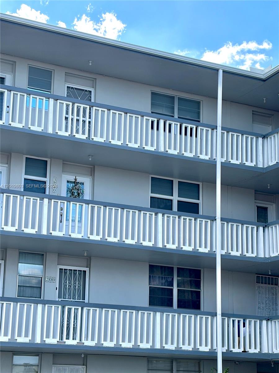 The exterior of a multi-story apartment building features white railings and numbered entry doors — 18601 NE 14th ave # 301, Miami FL 33179, MIAMI, FL