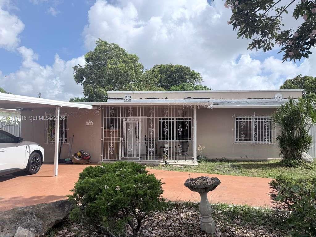 A single-story house with a carport, security bars on windows, and a paved front yard — 951 E 18th St, Hialeah FL 33013, HIALEAH, FL