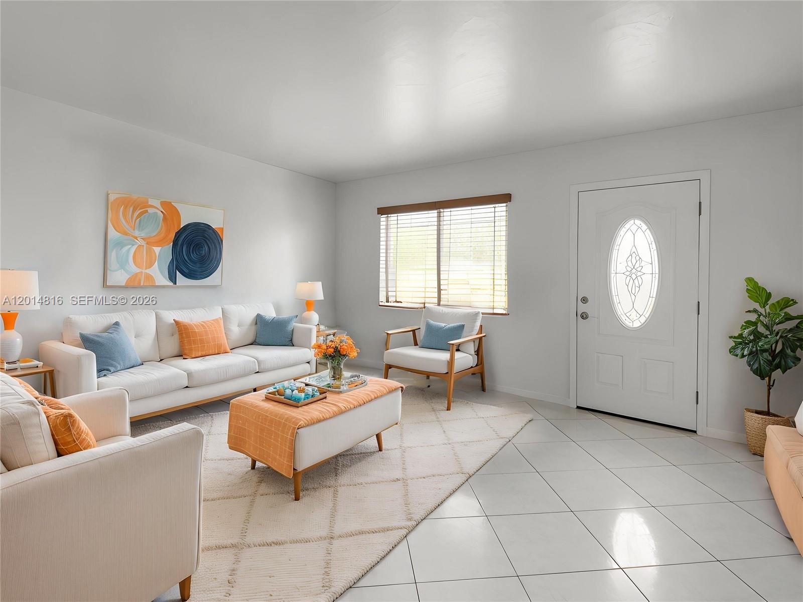 A bright living room features white tile floors, a white sofa, and a front door — 951 E 18th St, Hialeah FL 33013, HIALEAH, FL