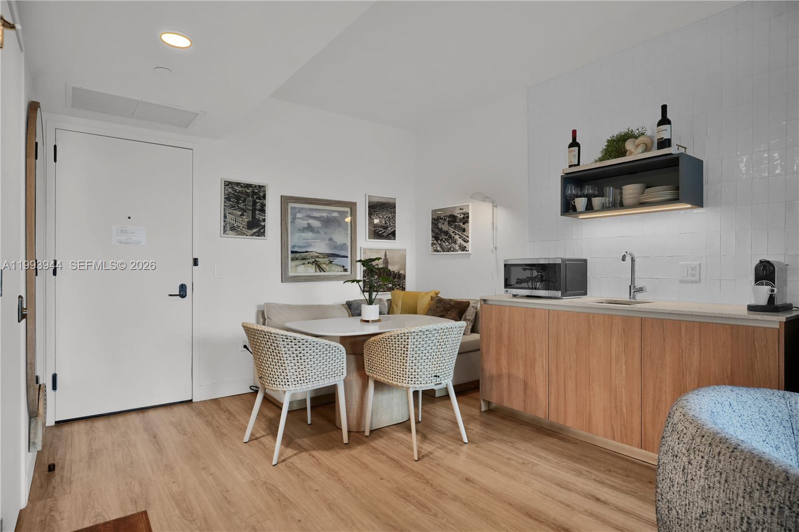 A small kitchen area features light wood cabinets, a dining nook, and white wall tiles — 159 NE 6th St # 1809, Miami FL 33132, MIAMI, FL