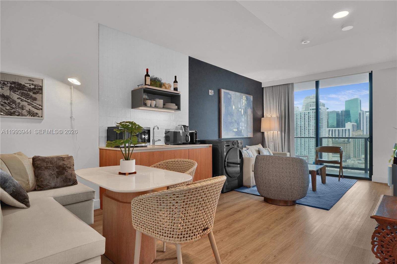 A modern studio apartment features a kitchenette, dining area, and floor-to-ceiling windows with city views — 159 NE 6th St # 1809, Miami FL 33132, MIAMI, FL