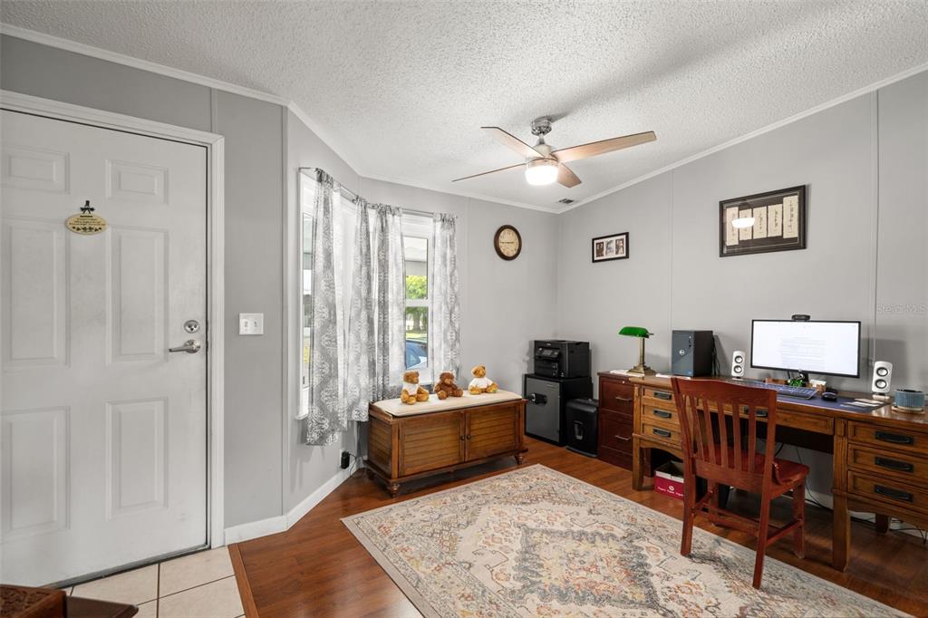 A home office with wood flooring, a wooden desk, a window bench, and a ceiling fan — 116 MOUNT ISLE AVENUE NE UNIT 116, ST PETERSBURG, FL