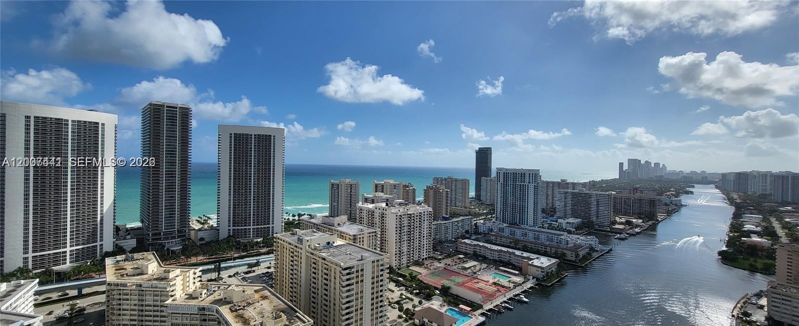 An elevated view of a coastal city skyline featuring high-rise buildings and a waterway — 2602 E Hallandale Beach Blvd # R306, Hallandale Beach FL 33009, HALLANDALE BEACH, FL