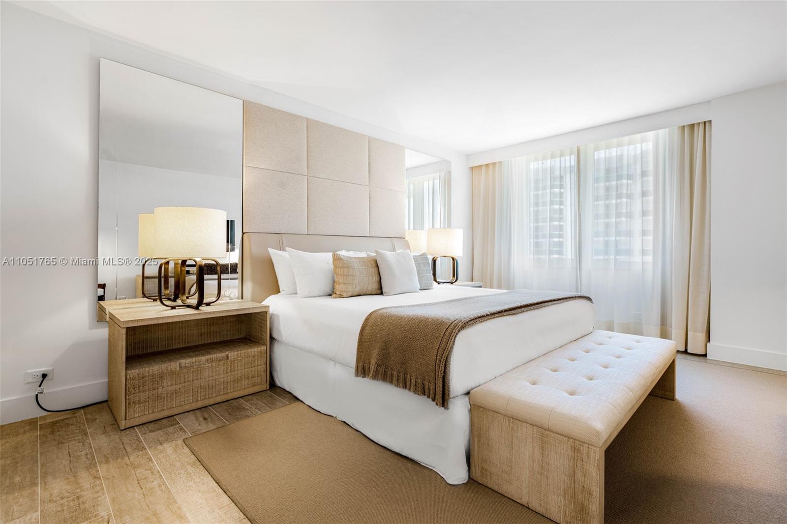 A bedroom features a tufted headboard, a bench at the foot of the bed, and mirrors — 102 24th St # 1115, Miami Beach FL 33139, MIAMI BEACH, FL