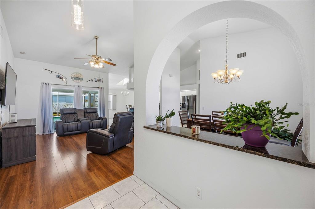 A living room and dining area are separated by a white arched wall opening — 23530 CLAY AVENUE, PORT CHARLOTTE, FL