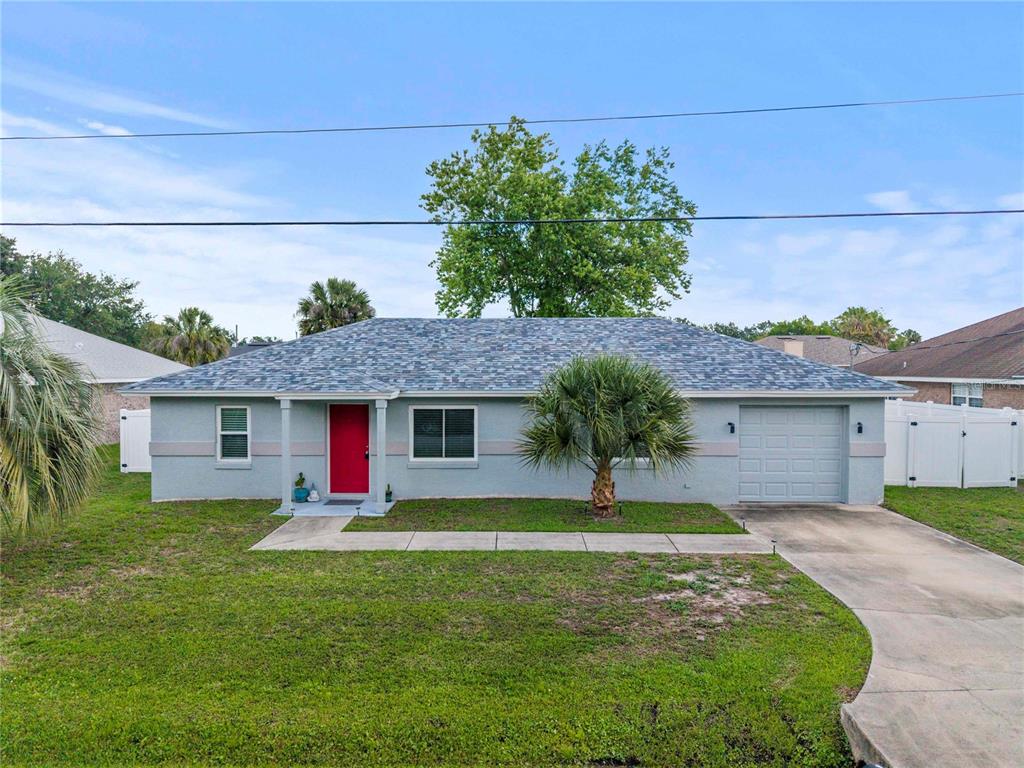 A single-story house with a gray exterior, a red front door, and a one-car garage — 9 BILTWELL PLACE, PALM COAST, FL