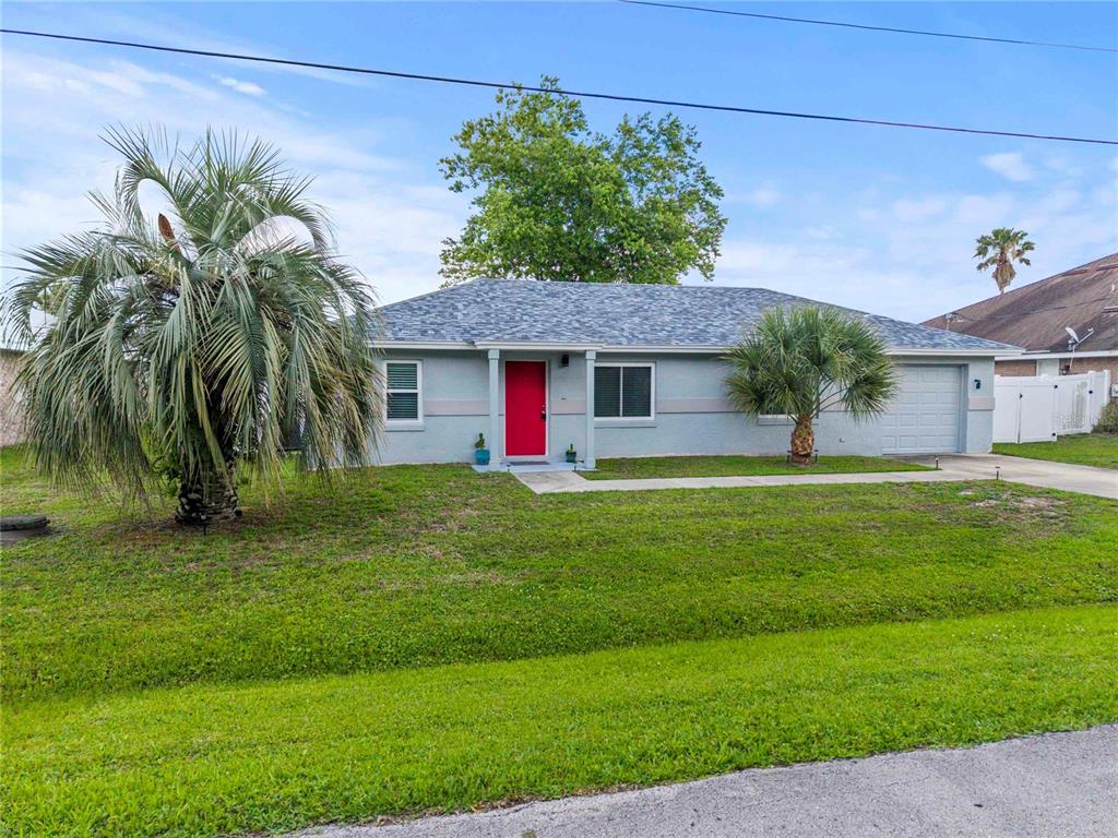 A single-story house with a red front door, gray siding, and a palm tree — 9 BILTWELL PLACE, PALM COAST, FL